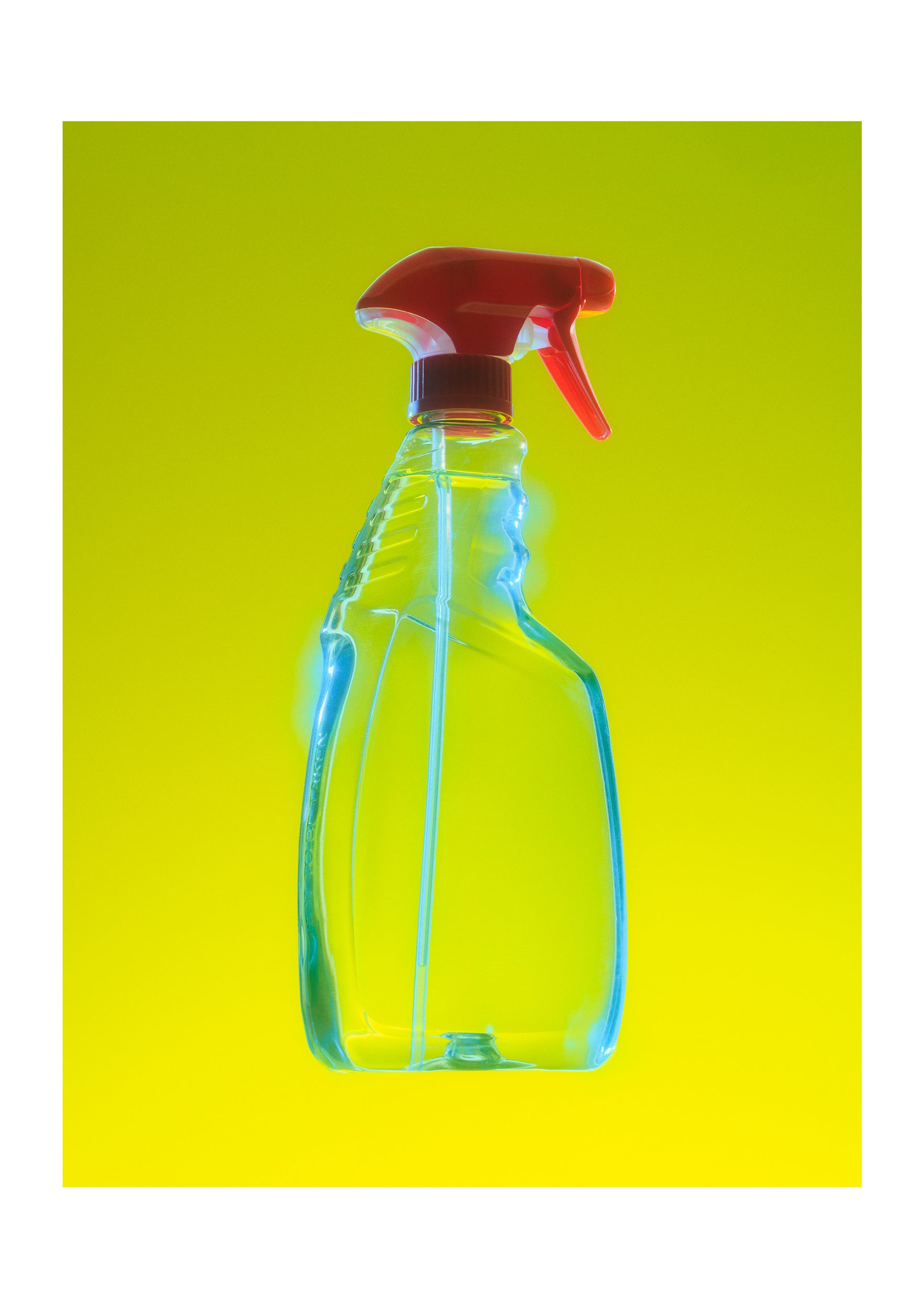 A clear plastic spray bottle with a red trigger sprayer, shown against a bright yellow-to-green gradient background.