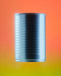 A metallic silver cylindrical can centered on a smooth gradient background that transitions from orange at the top to yellow at the bottom.